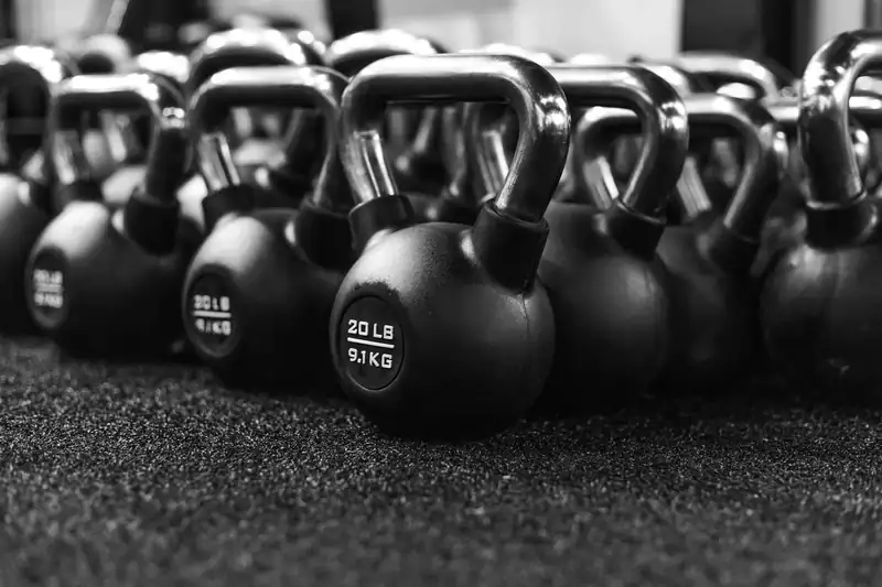 Fileira de kettlebells no piso emborrachado